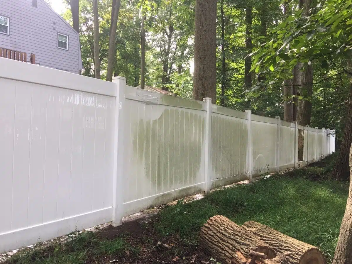 Pressure washing a vinyl fence, removing algae and green staining