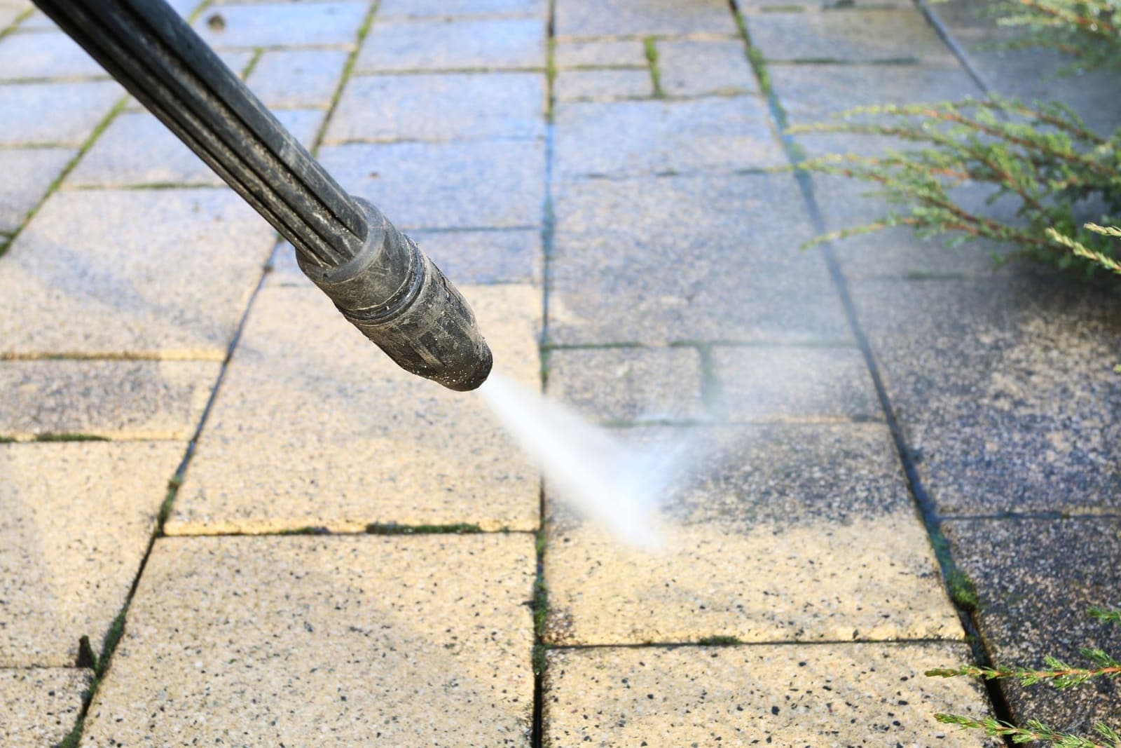 Professional pressure washing a concrete patio surface